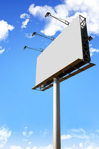 Low angle view of road sign against blue sky