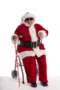 A nonagenarian in a santa claus costume sitting on a pushcart
