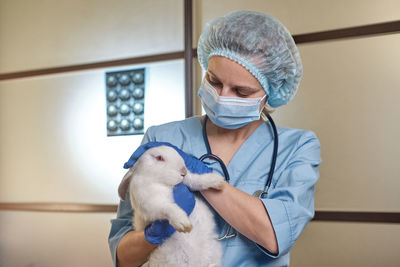 Female nurse holding rabbit at hospital