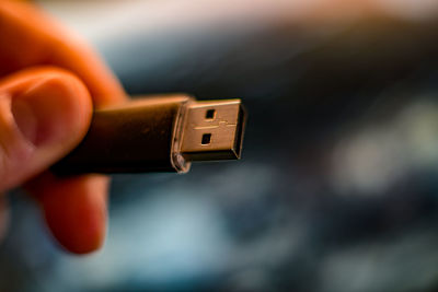Close-up of hand holding usb cable