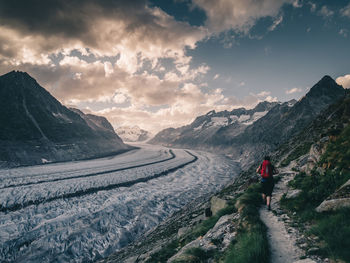 Rear view of person on snowcapped mountains against sky