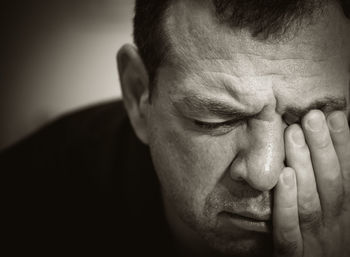 Close-up of depressed mature man with hand on face