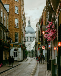 People walking on street amidst buildings in city