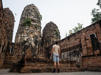 Low angle view of man standing against ancient temple