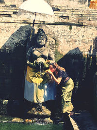 Statue of buddha against brick wall