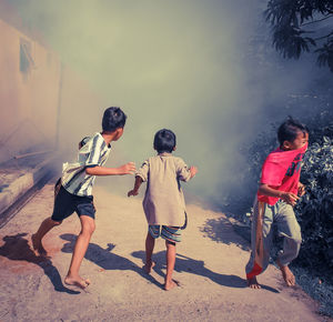 Rear view of people with arms outstretched