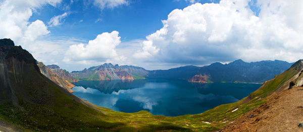Scenic view of mountains and calm lake against sky