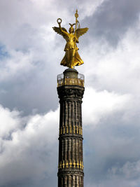 Low angle view of tower against cloudy sky