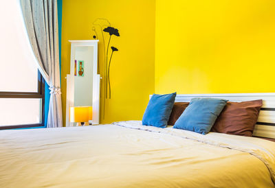 View of yellow bed in bedroom