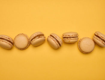 High angle view of macaroons on yellow background