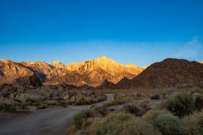 Scenic view of landscape and mountains against blue sky