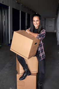 Portrait of smiling young woman holding camera in box