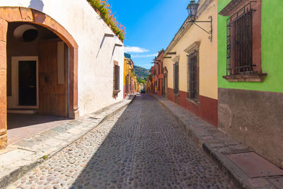 Empty alley amidst buildings in city