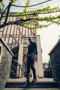 Low angle view of man standing by building