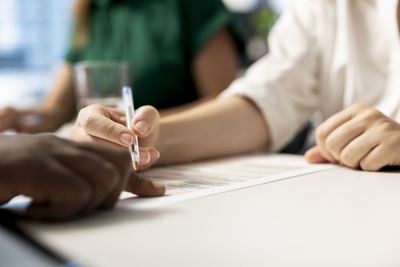 Midsection of business colleagues working at table