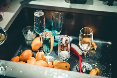 Close-up of champagne flutes and lemon slices in sink