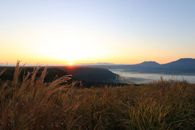 Scenic view of land against clear sky during sunset