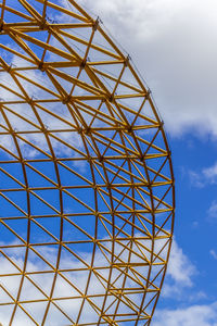 Low angle view of grid structure against sky