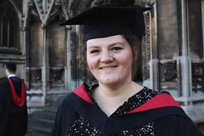 Close-up portrait of young woman in graduation gown