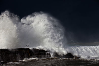 Water splashing in sea against sky