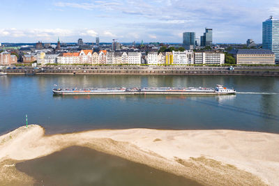 Scenic view of sea by buildings against sky