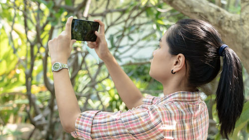 Portrait of woman photographing with mobile phone