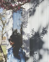 Young woman standing against wall