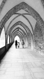 Rear view of people walking in corridor of building