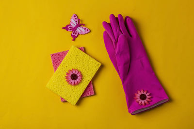 Rubber gloves and sponges waiting for washing on a yellow background