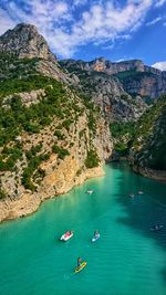 Aerial view of people in sea by mountains