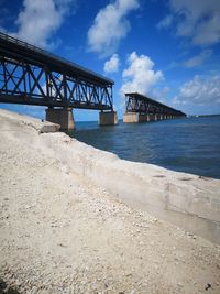 Bridge over sea against blue sky