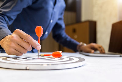 Midsection of man playing with ball on table