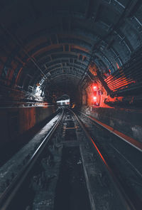 Railroad tracks in illuminated tunnel