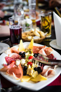 Close-up of antipasto with serving tongs in plate on table at restaurant