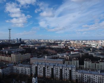 High angle view of city buildings against cloudy sky