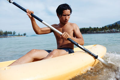 Man kayaking in sea