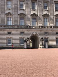 Sentry of the grenadier guards posted outside buckingham palace in a sunny day, london, uk