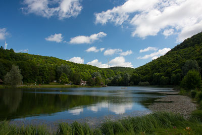 Scenic view of lake in forest against sky