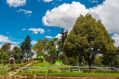 Scenic view of fenced in farm against cloudy sky