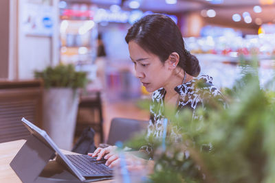 Concentrate woman working on laptop computer in coffee shop.