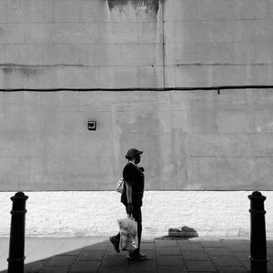 Rear view of woman walking on footpath