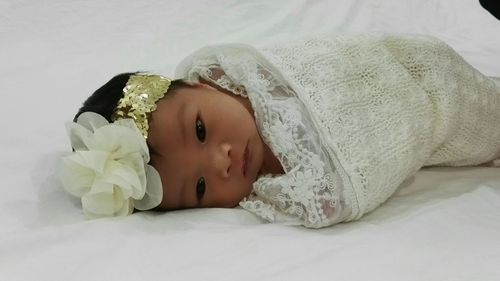 Close-up of cute newborn baby girl wrapped in blanket