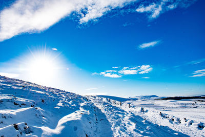 Scenic view of snowcapped mountains against blue sky