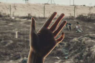 Cropped hand of woman against landscape