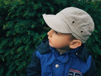 Cute boy wearing cap while looking away in park during winter
