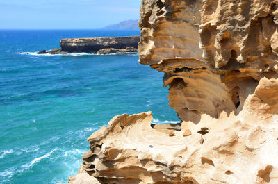 Scenic view of rock formation in sea against sky