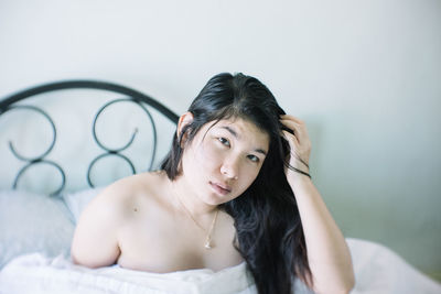 Portrait of young woman on bed at home