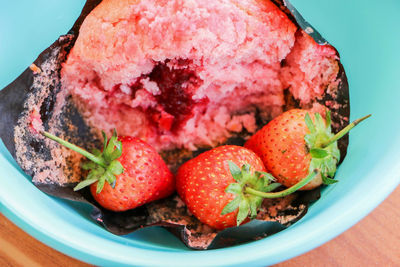 Strawberry muffins in a green cup that has already been eaten