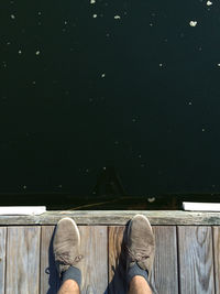 Low section of person standing on wooden pier