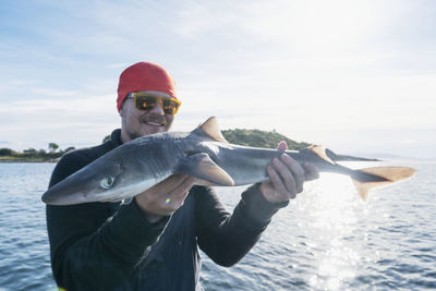 Man on boat holding fish